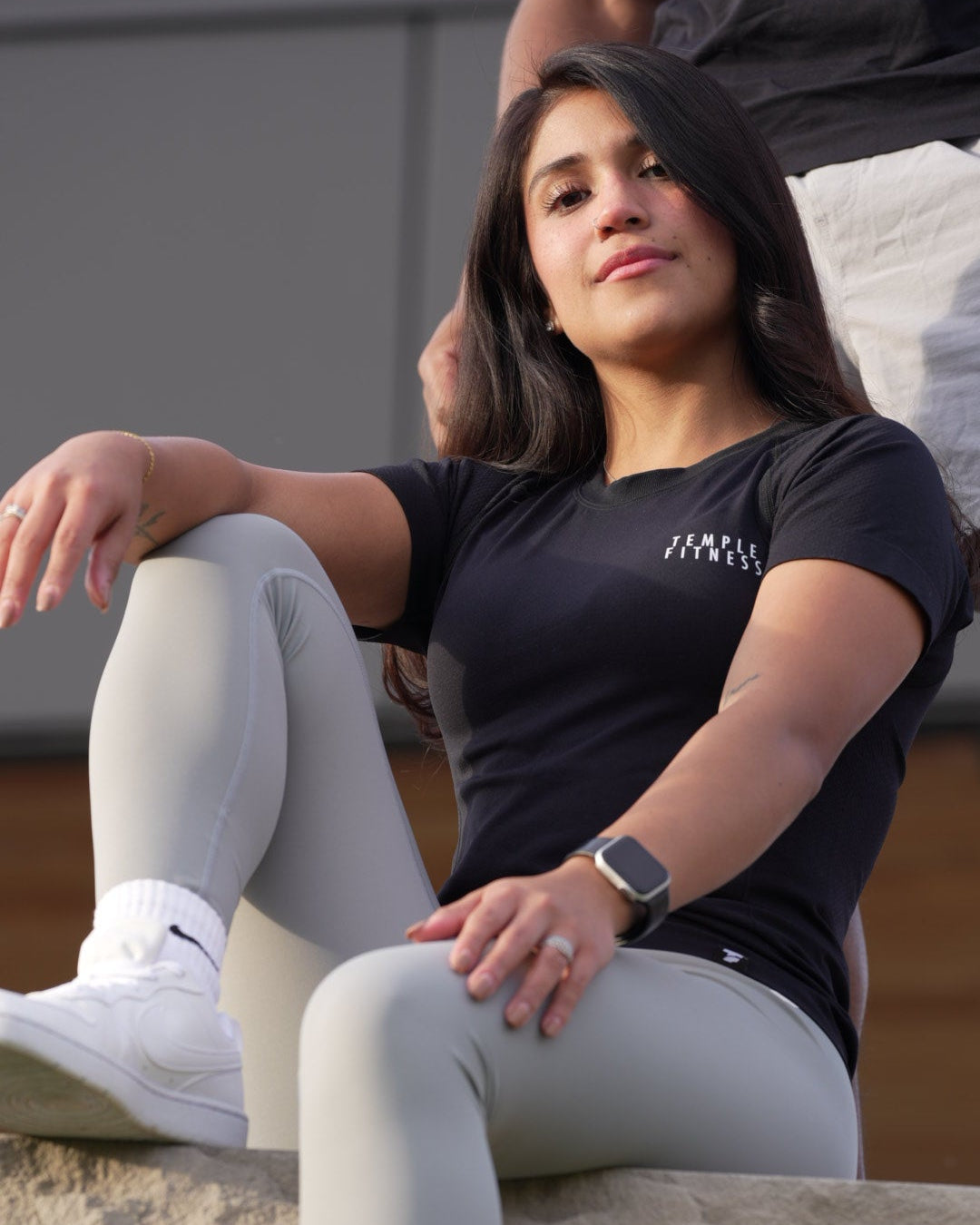 Person wearing a black shirt and gray leggings climbing a rock wall.